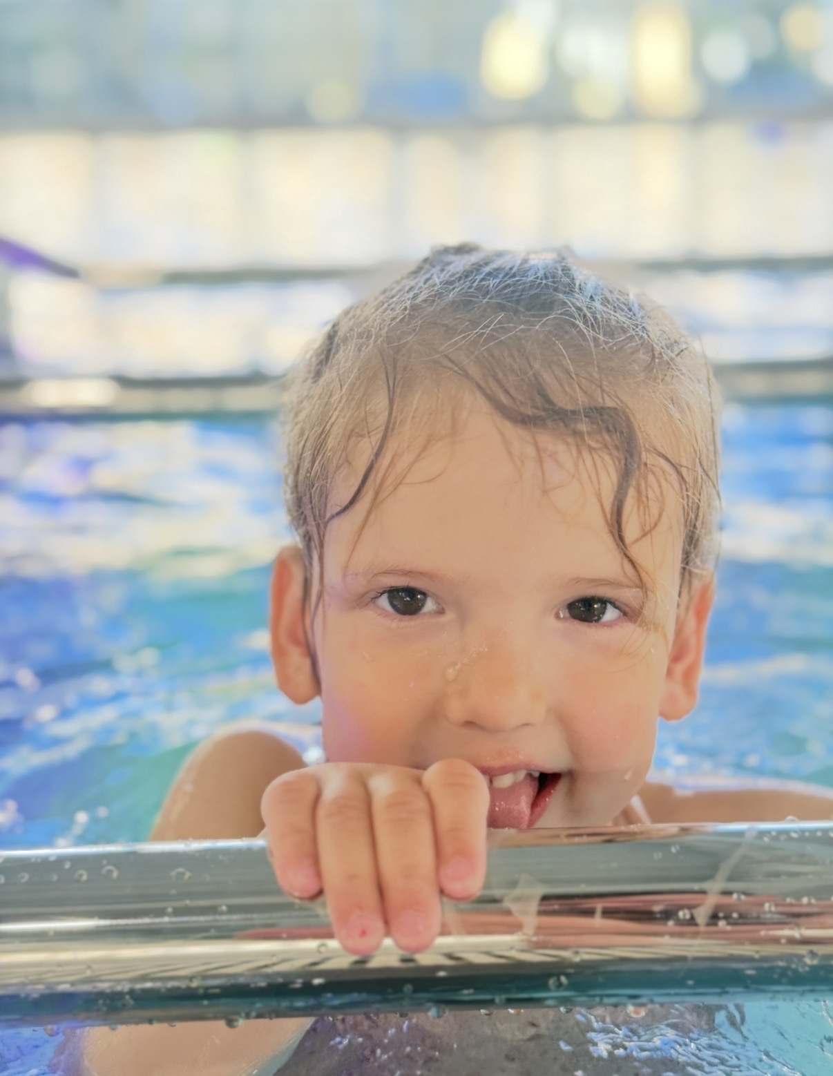 Kind lacht am Beckenrand im Schwimmbad Nottwil.